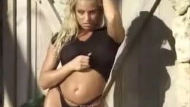 Trish Stratus in a black see-through shirt and thong