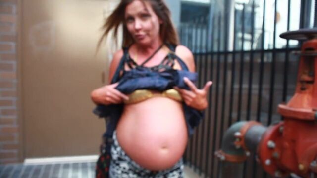 Pregnant street-Showing off the belly in a bikini top